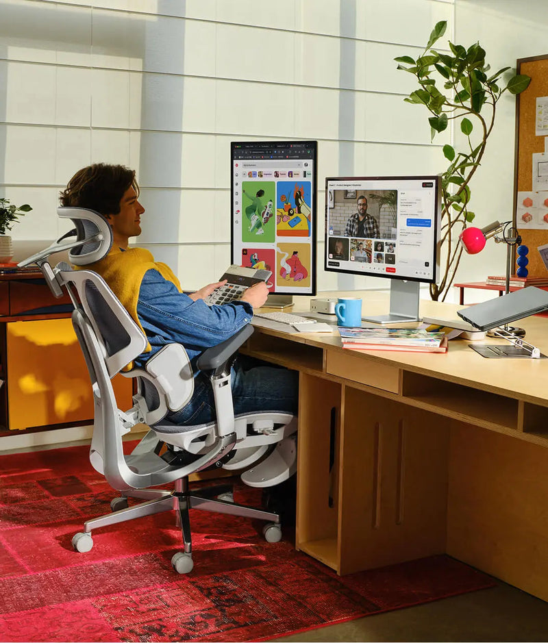 Man working at a twin-monitor desk in the HBADA E3 Pro