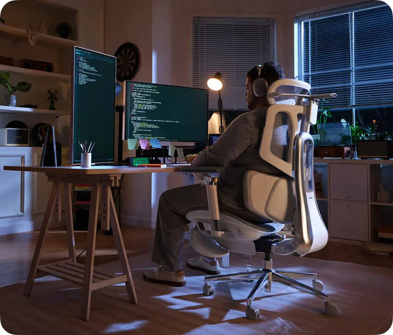 Software engineer coding at a dual-monitor desk in the HBADA X7