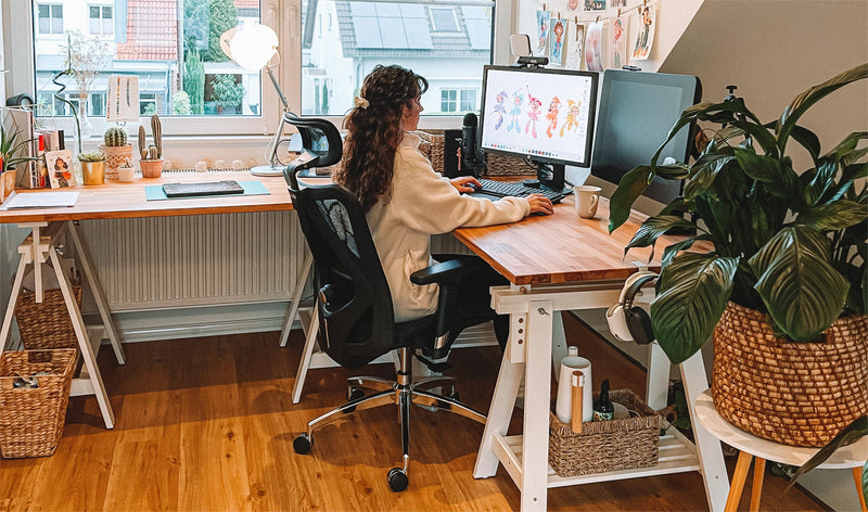 A creative working at a home studio desk in the Sihoo M57